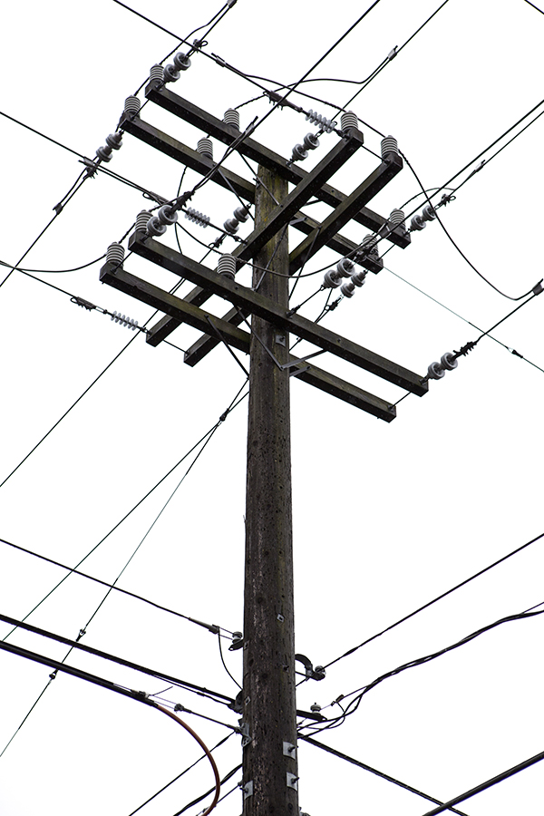 The wires of a telephone pole create a geometric pattern across a cold grey sky in Seattle, Washington